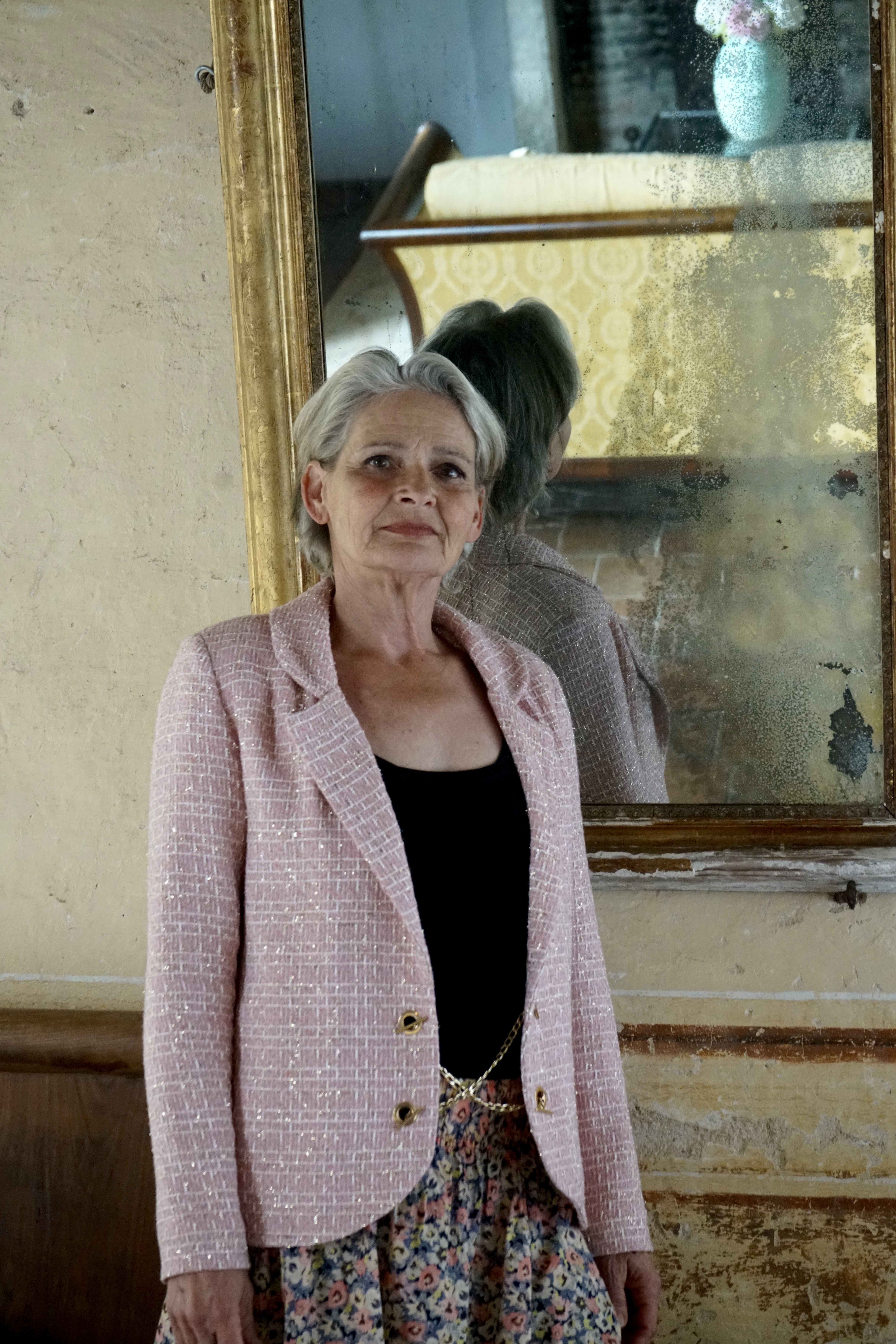 Model in pink woven jacket front view with mirror behind, close up